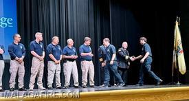 Graduates receiving congratulations from their academy instructors before being handed their certificates. 